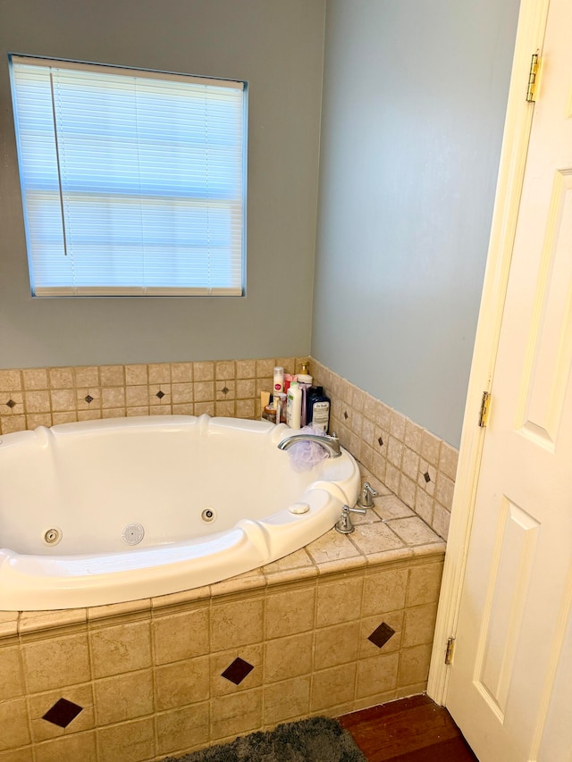 bathroom featuring wood-type flooring and tiled tub