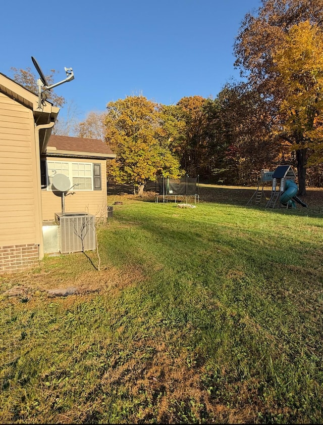 view of yard with central AC and a trampoline