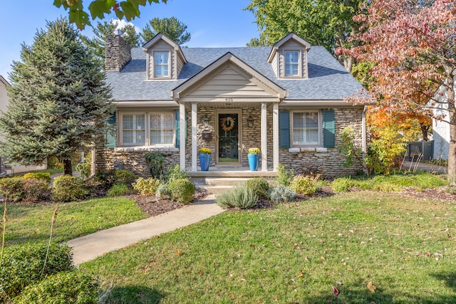 new england style home featuring a porch and a front yard