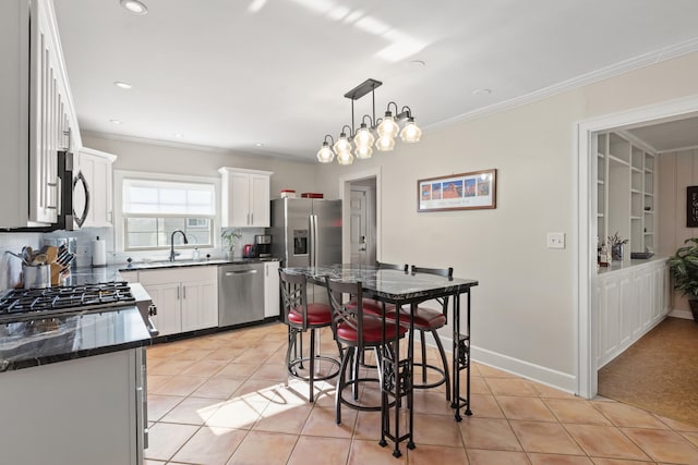 kitchen with white cabinets, hanging light fixtures, an inviting chandelier, sink, and stainless steel appliances