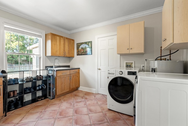 clothes washing area with sink, washer and dryer, ornamental molding, and cabinets