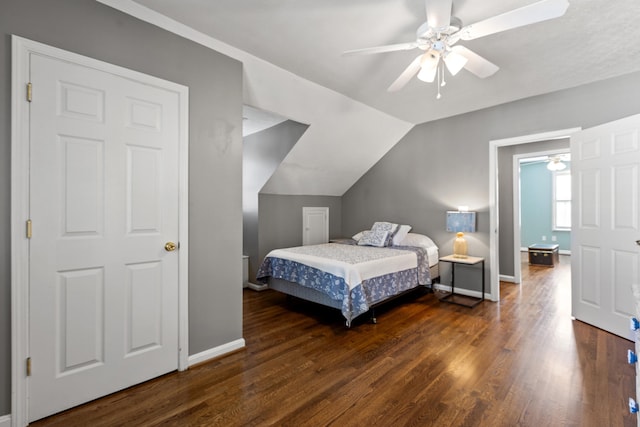 bedroom featuring dark hardwood / wood-style flooring, vaulted ceiling, and ceiling fan