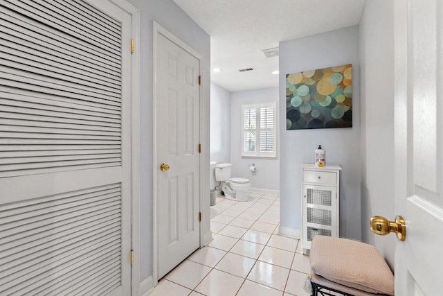 bathroom featuring toilet and tile patterned flooring