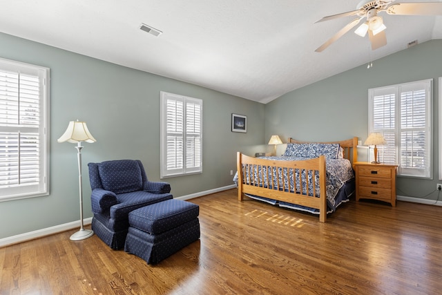 bedroom featuring lofted ceiling, wood-type flooring, and multiple windows