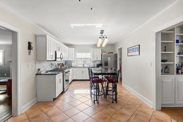 kitchen featuring ornamental molding, sink, light tile patterned flooring, white cabinetry, and appliances with stainless steel finishes