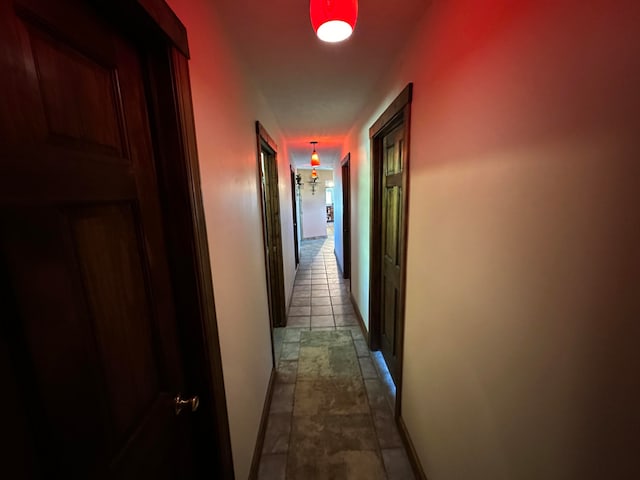 hall featuring dark tile patterned flooring