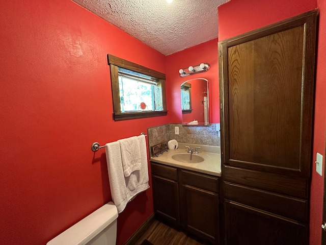 bathroom featuring vanity, toilet, and a textured ceiling