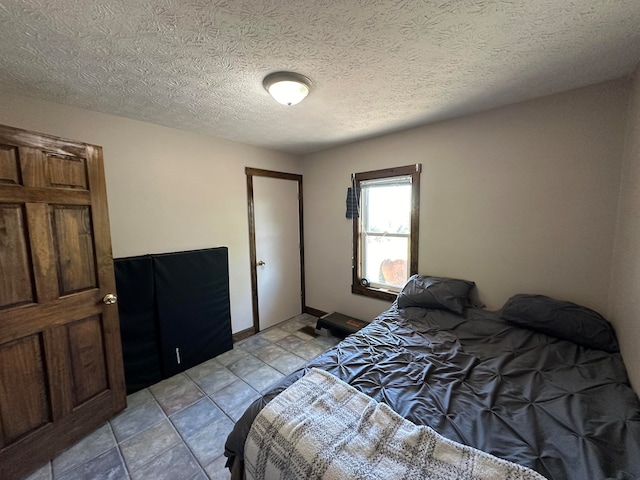 bedroom with a textured ceiling and light tile patterned floors