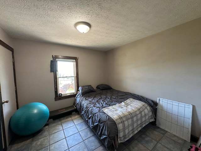 tiled bedroom featuring a textured ceiling