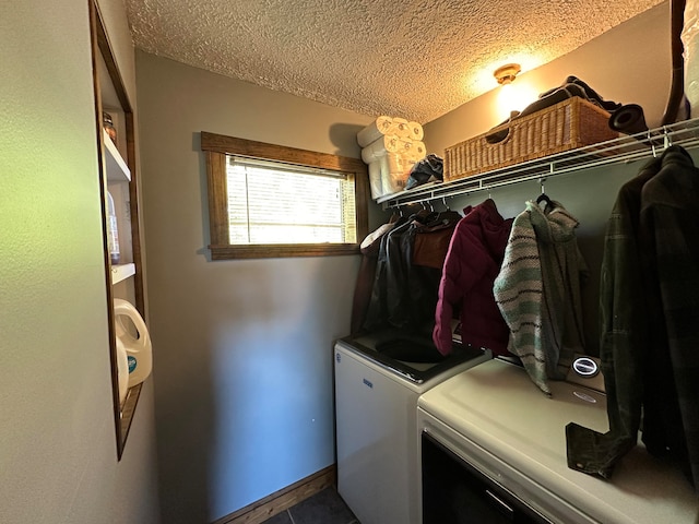 clothes washing area featuring a textured ceiling and washer and clothes dryer