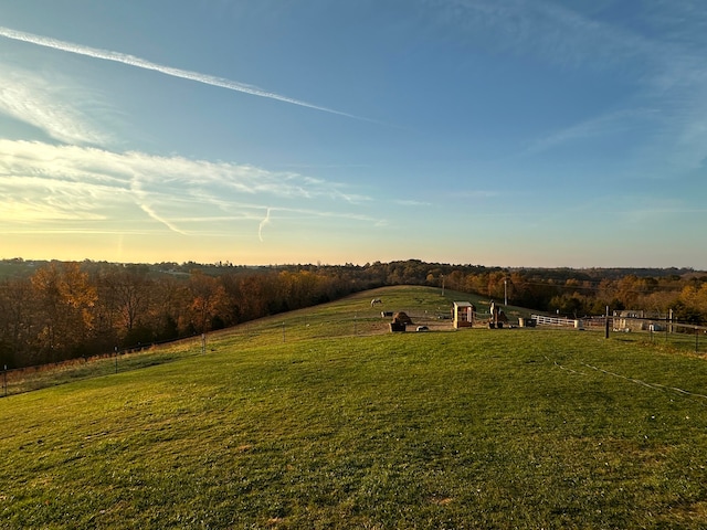 yard at dusk featuring a rural view