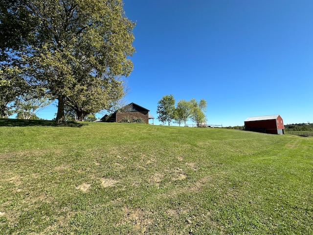 view of yard featuring a rural view and an outdoor structure