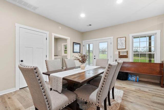 dining space with french doors, light wood-type flooring, visible vents, and baseboards