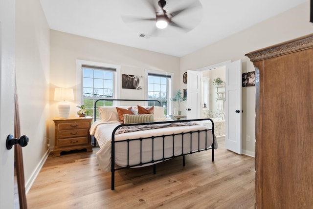 bedroom featuring light wood-style floors, visible vents, baseboards, and ensuite bathroom