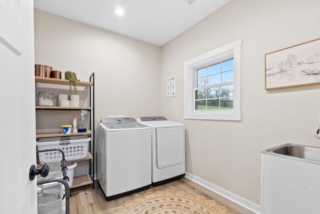 clothes washing area featuring laundry area, baseboards, washer and clothes dryer, light wood-style flooring, and recessed lighting