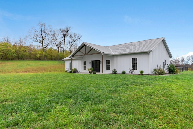 view of front of home with metal roof and a front lawn