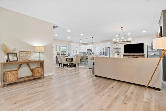 living room with a chandelier, recessed lighting, visible vents, and light wood-style floors