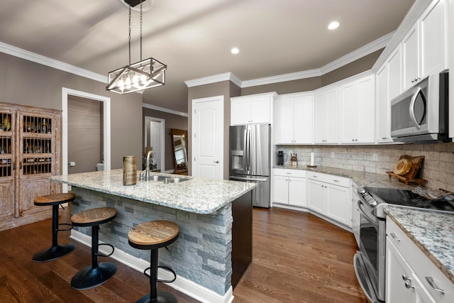 kitchen featuring light stone countertops, stainless steel appliances, sink, and an island with sink