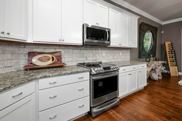 kitchen with light stone countertops, appliances with stainless steel finishes, white cabinets, crown molding, and dark hardwood / wood-style floors