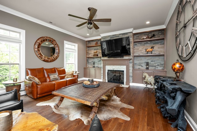 living room featuring a large fireplace, ceiling fan, dark hardwood / wood-style floors, crown molding, and baseboard heating