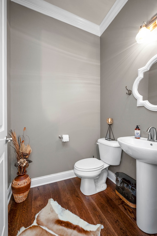 bathroom with toilet, crown molding, sink, and wood-type flooring