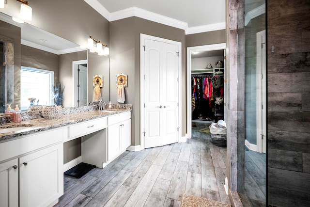 bathroom with vanity, crown molding, and hardwood / wood-style flooring