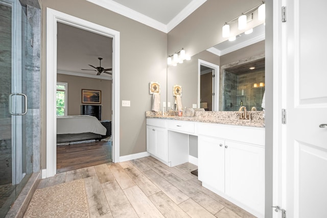 bathroom featuring vanity, ornamental molding, wood-type flooring, and an enclosed shower