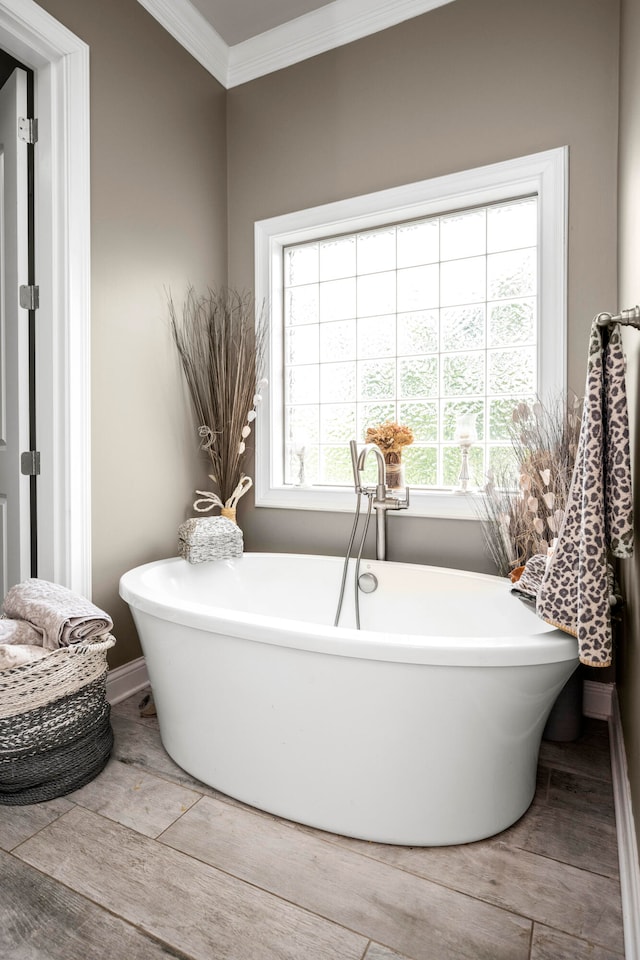 bathroom featuring ornamental molding, a washtub, and hardwood / wood-style floors