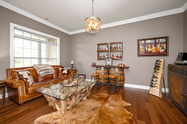 living room with dark wood-type flooring, crown molding, bar, and a chandelier