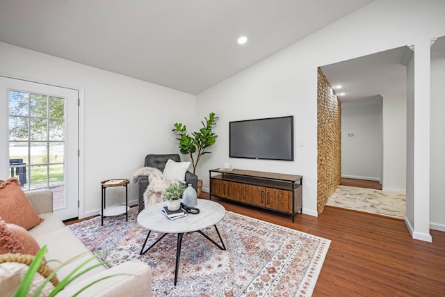 living room featuring lofted ceiling and hardwood / wood-style flooring