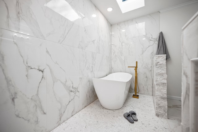 bathroom with a bathing tub, a skylight, and tile walls