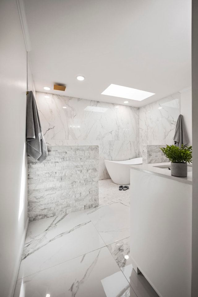 bathroom featuring tile walls, a bathtub, and a skylight