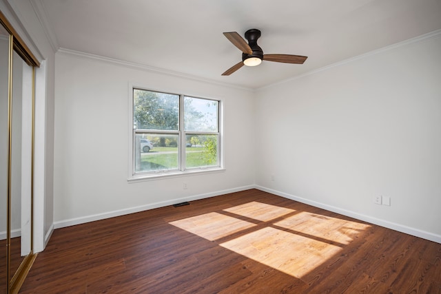 unfurnished bedroom featuring ornamental molding, dark wood-type flooring, a closet, and ceiling fan