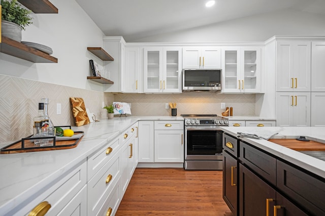 kitchen featuring appliances with stainless steel finishes, decorative backsplash, white cabinets, and light wood-type flooring