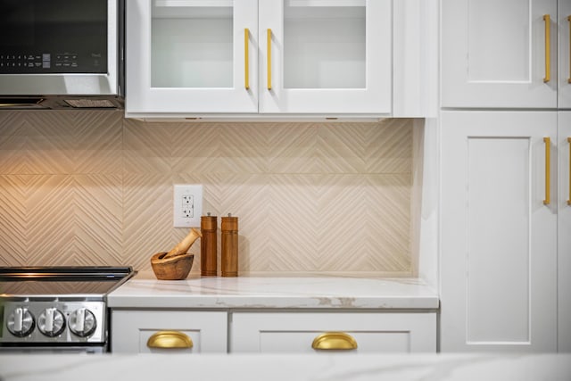 kitchen featuring light stone countertops and white cabinets