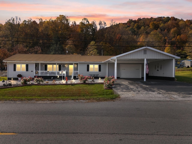 ranch-style house featuring a garage, a carport, a lawn, and a porch