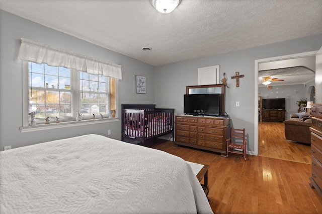 bedroom with a textured ceiling and dark hardwood / wood-style flooring