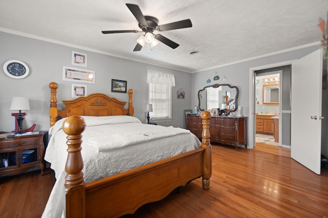 bedroom with ensuite bathroom, a textured ceiling, hardwood / wood-style floors, ceiling fan, and ornamental molding