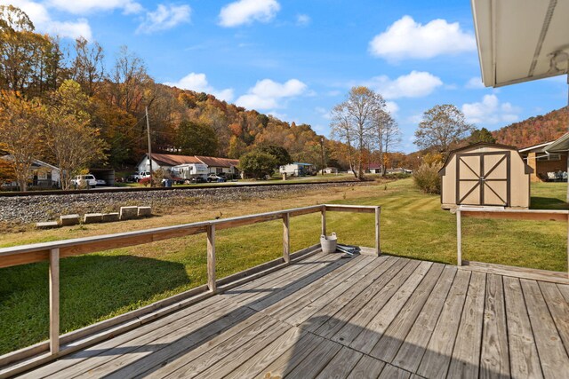 deck featuring a shed, a lawn, and a mountain view