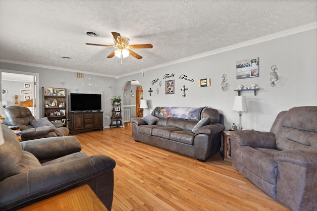 living room with ornamental molding, light hardwood / wood-style flooring, a textured ceiling, and ceiling fan