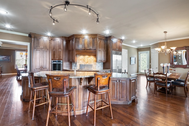 kitchen with stainless steel appliances, dark wood-type flooring, an island with sink, and plenty of natural light