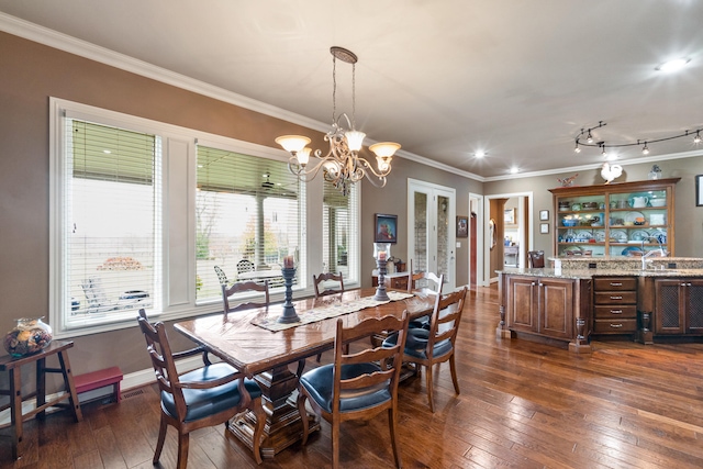 dining space with ornamental molding, an inviting chandelier, and dark hardwood / wood-style floors