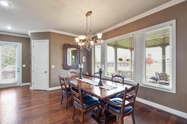 dining room with dark hardwood / wood-style floors, an inviting chandelier, and crown molding