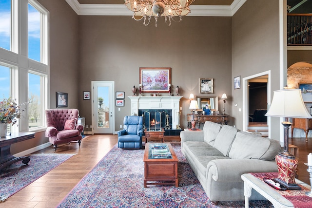 living room featuring ornamental molding, light wood-type flooring, and a wealth of natural light