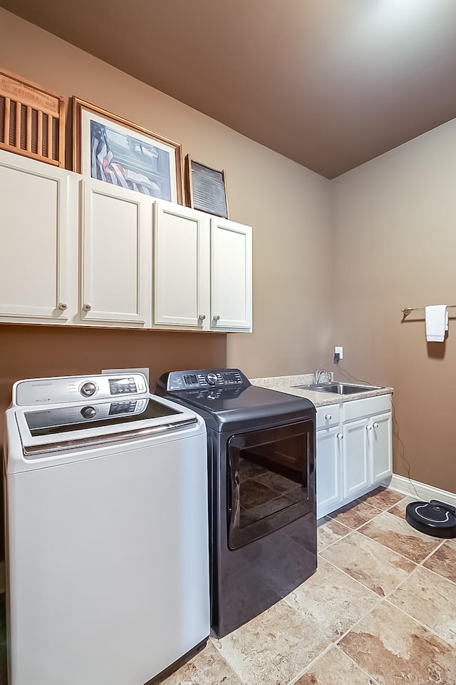 laundry room with cabinets, sink, and separate washer and dryer