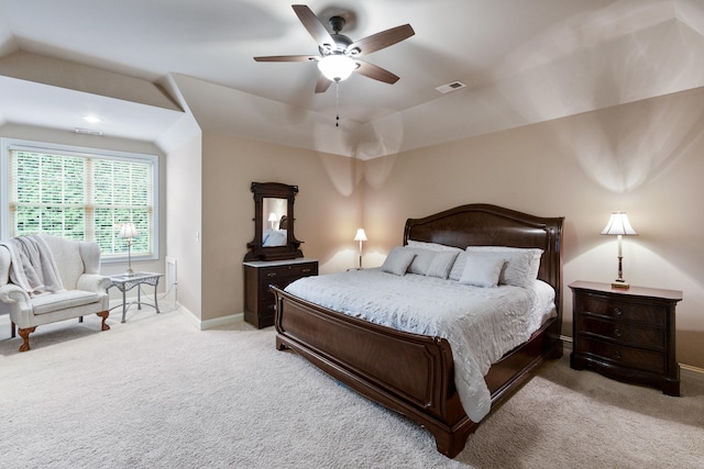 bedroom with vaulted ceiling, light colored carpet, and ceiling fan