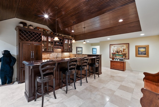 bar featuring vaulted ceiling, wooden ceiling, dark brown cabinets, backsplash, and pendant lighting