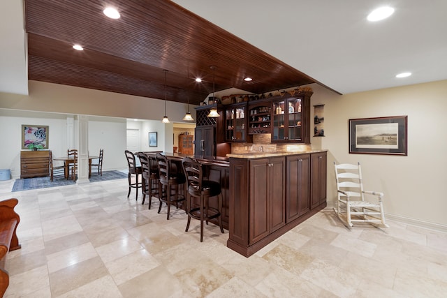 bar featuring hanging light fixtures and dark brown cabinetry