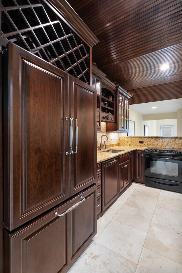 kitchen featuring black / electric stove, light tile patterned floors, sink, light stone countertops, and dark brown cabinets