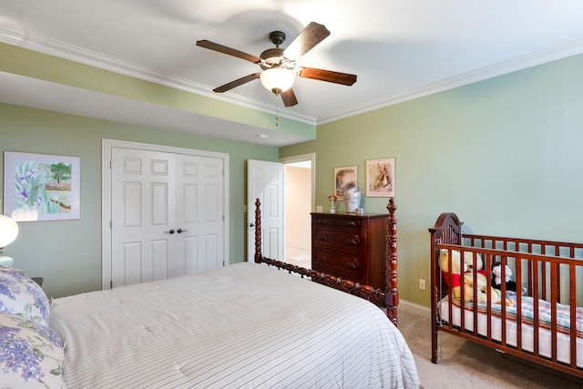 carpeted bedroom featuring ceiling fan, a closet, and ornamental molding